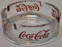 1990 COCA COLA KÜL TABLASI BEYAZ CAM ÜZERİNE KIRMIZI YAZILI YUVARLAK FORMDA SIGARA TABLASI