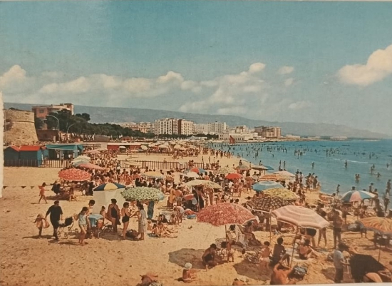 1970 BU KARTPOSTAL, İTALYA’DA MANFREDONIA ŞEHRİNİN PLAJINI TANITAN BİR TEBRİK KARTIDIR. ÖN YÜZÜNDE KALABALIK BİR PLAJ