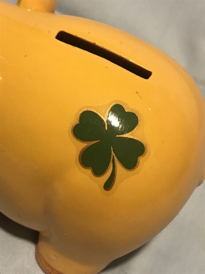 GARANTİ BANKASI SERAMİK DOMUZ KUMBARA AGZINDA DÖRT YONCALI YAPRAK OLAN KUMBARADIR