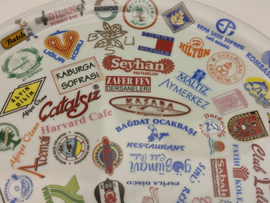 NECMİ SANATCI İMZALI KANADA DAMGALI ÜZERİNDE BİRCOK TANINMIŞ MARKA LOGOLARI BASKILI PORSELEN TABAK