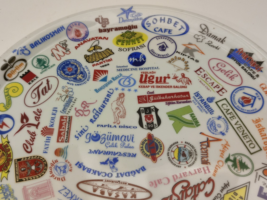 NECMİ SANATCI İMZALI KANADA DAMGALI ÜZERİNDE BİRCOK TANINMIŞ MARKA LOGOLARI BASKILI PORSELEN TABAK