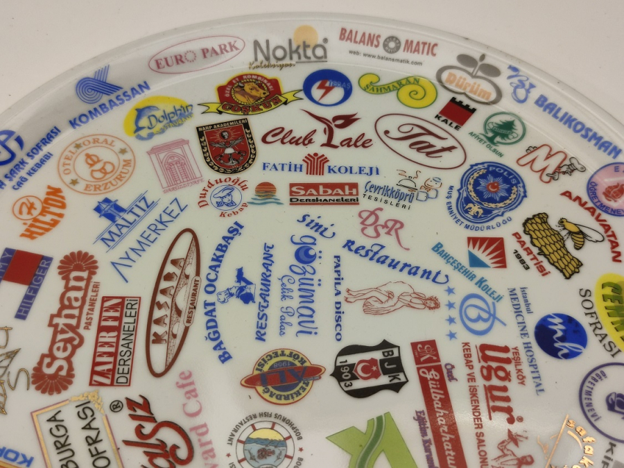 NECMİ SANATCI İMZALI KANADA DAMGALI ÜZERİNDE BİRCOK TANINMIŞ MARKA LOGOLARI BASKILI PORSELEN TABAK