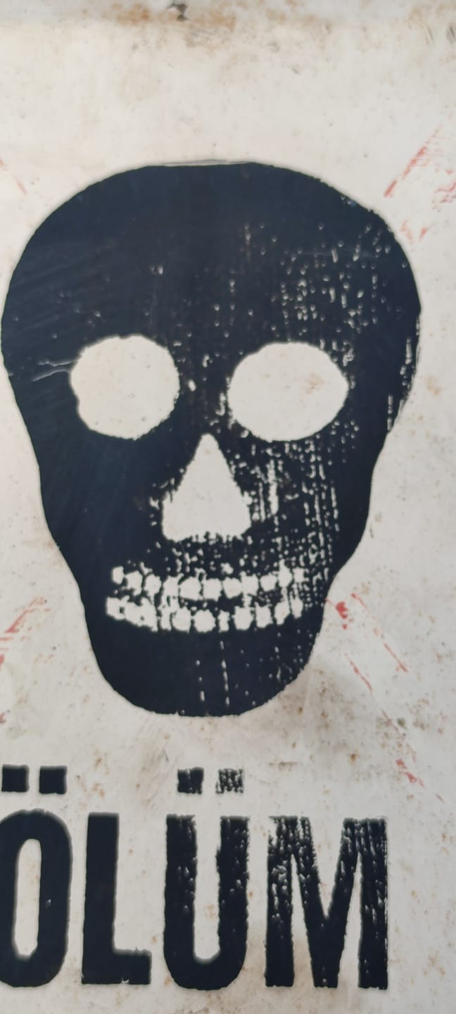 1970 BEYAZ ZEMİN ÜZERİNE SİYAH VE KIRMIZI RENKDE İŞARETLENMİŞ  KURU KAFA METAL TEHLİKE UYARISI TABELASI